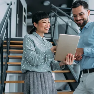 Collega’s bespreken een project op een tablet in een moderne kantooromgeving